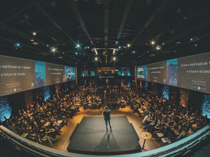 A speaker on stage in front of a full auditorium
