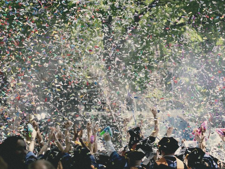 Confetti bursts over a crowd at an outdoor event