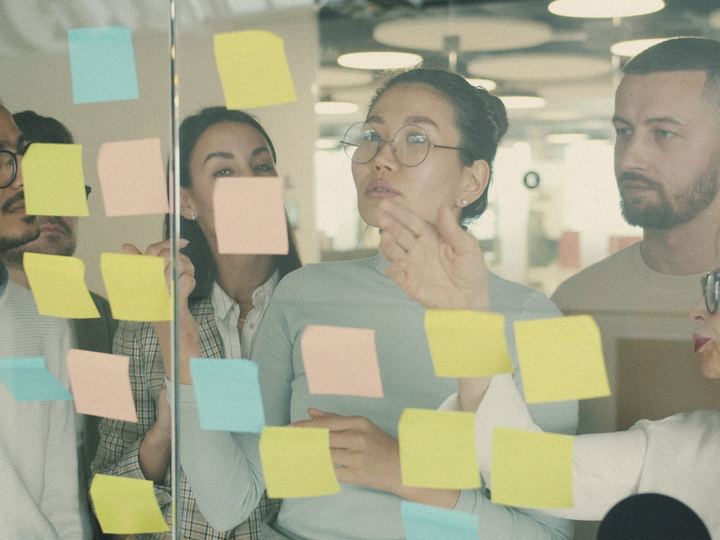 A team plans with sticky notes on a glass wall
