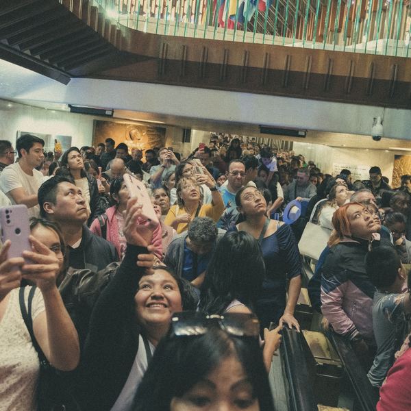 A crowd looks up in delight at an indoor event