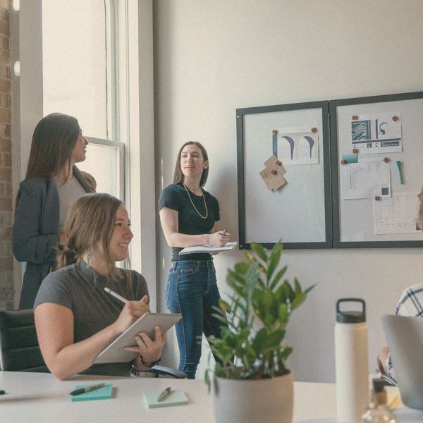 A small team talks through a plan in a sunlit office