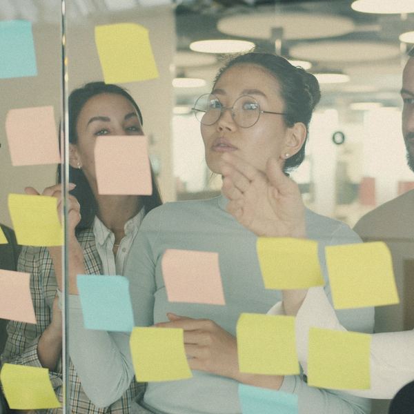 A team plans with sticky notes on a glass wall