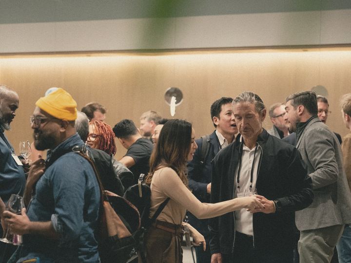 Visitors deep in conversation at a busy business event